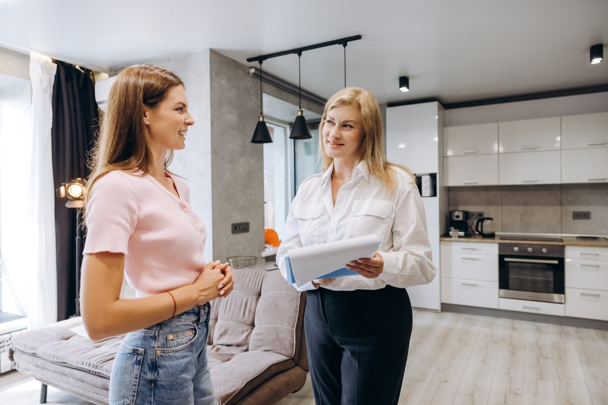 Woman talking with an estate agent in a modern apartment kitchen