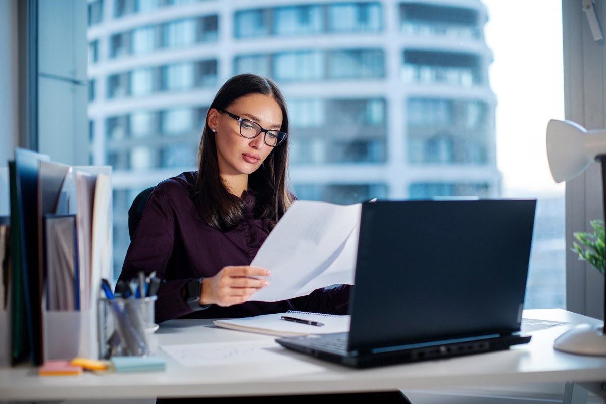 Woman reading documents at her desk
