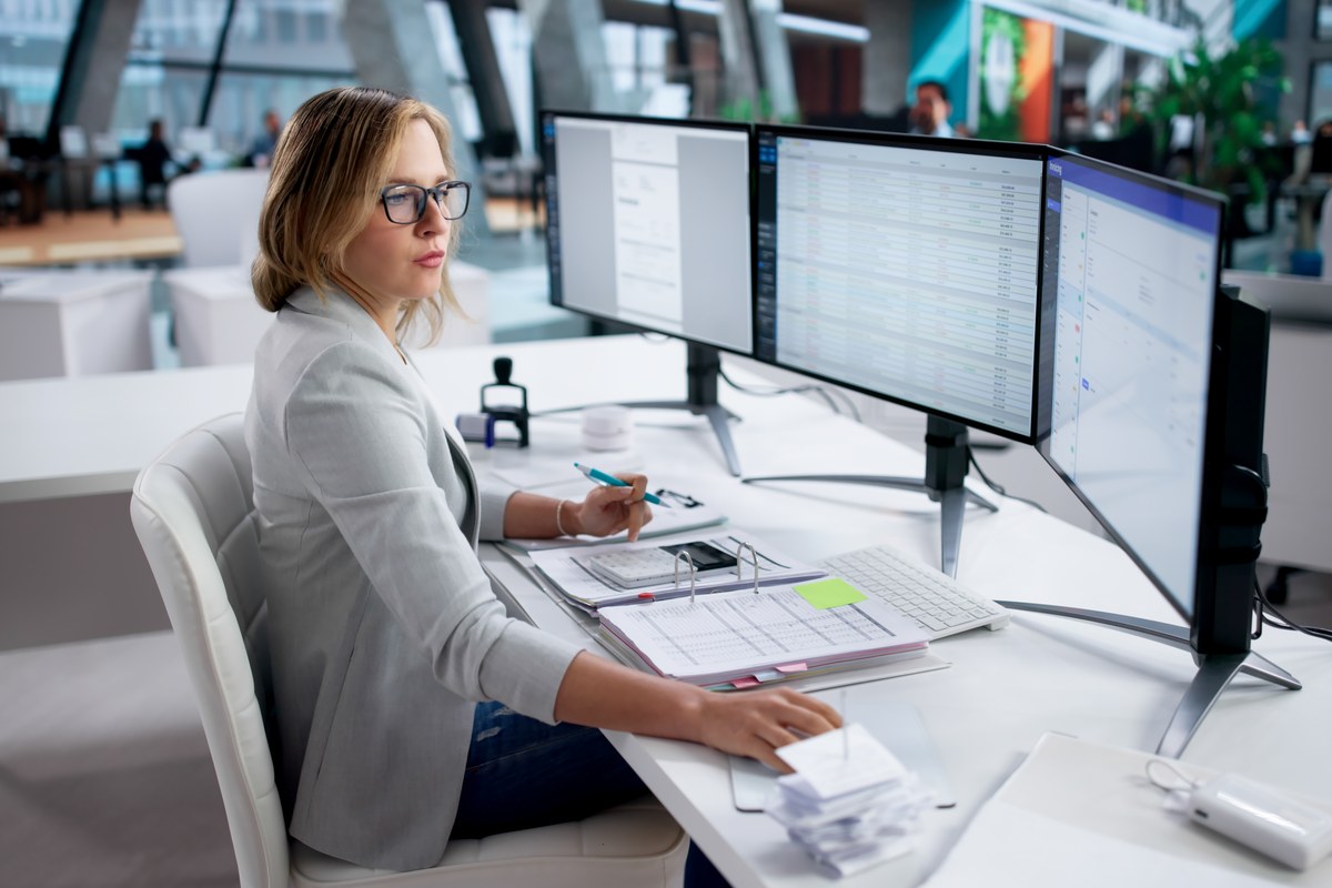 Woman working at a computer with spreadsheets