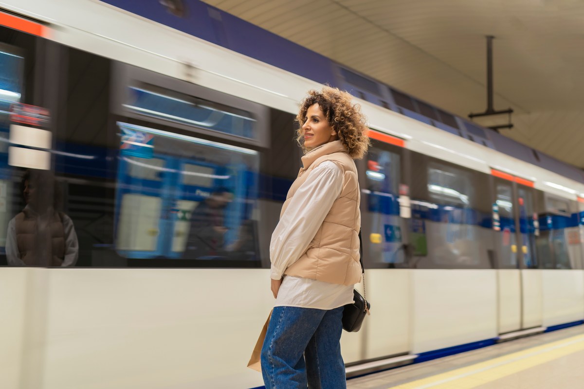 Woman waiting on a metro platform as a train pulls in