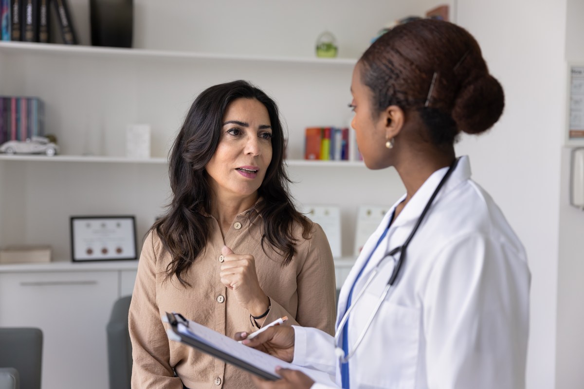 Woman talking with a female doctor in a clinic office
