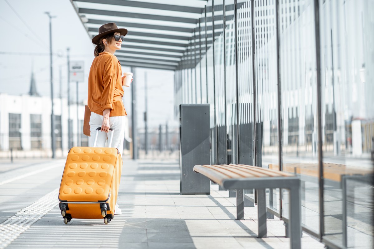 Woman with a yellow suitcase at a station