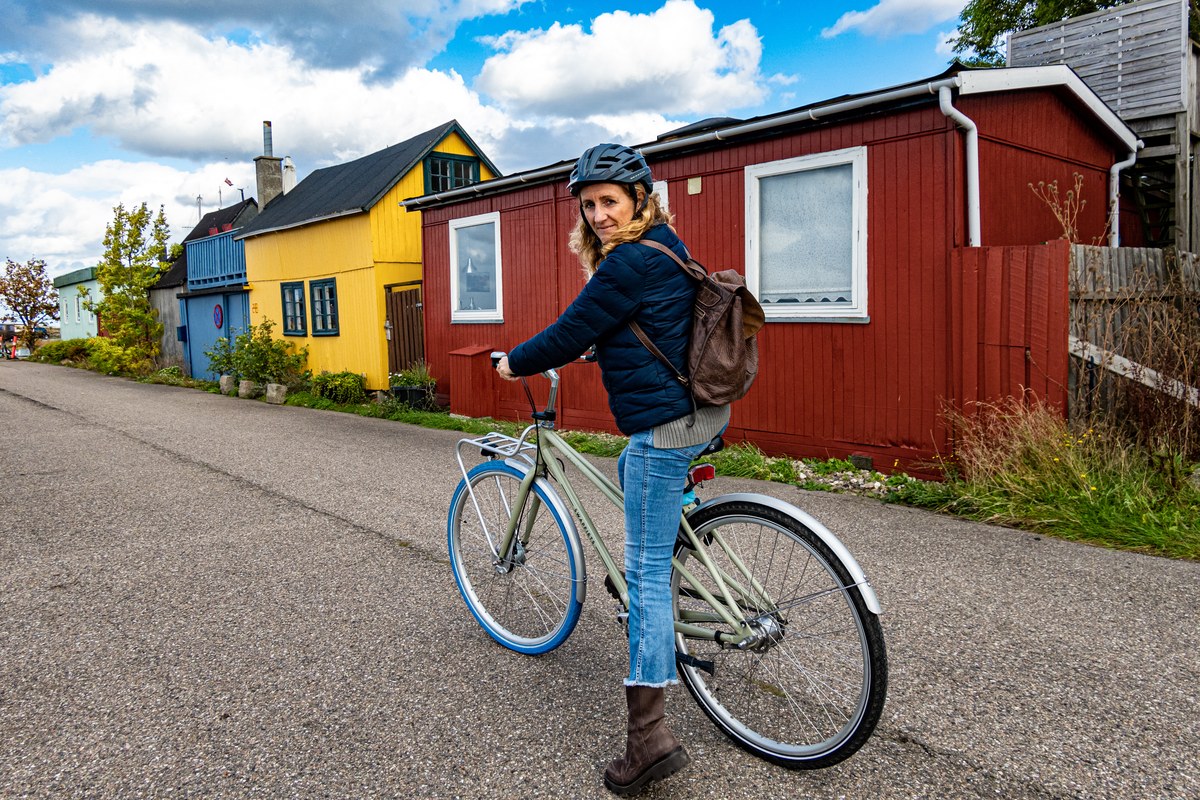 Woman with a bicycle on a street of painted wooden houses in Copenhagen