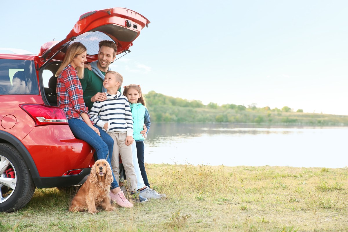 Family with their dog by the car